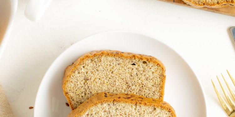 Top view of delicious sliced bread on a plate with tea and almonds.