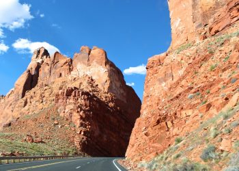 curved road in between brown rock cliffs